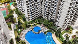 A high-rise residential building with multiple balconies, a central swimming pool, and surrounding landscaped gardens. - Amberside, Country Garden Danga Bay Homestay by Welcome Home (Johor Bahru)