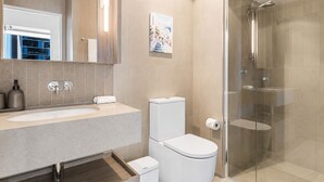 Un bagno moderno con un lavandino ampio, il water e una cabina doccia in vetro.
