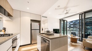 Una cucina moderna con isola centrale, elettrodomestici integrati e un'ampia finestra che offre vista sulla città.