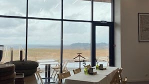 A dining area with a large window offering a view of a desert landscape. - Pana Unique Charyn (Enbekshikazakh District)