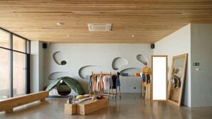 A spacious room with a wooden ceiling, a large window, and a clothing rack. - Pana Unique Charyn (Enbekshikazakh District)