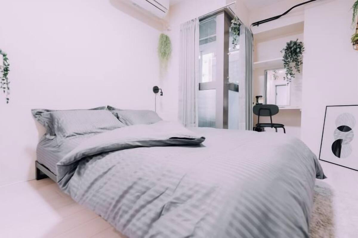 A bedroom with a bed, a desk, and a chair.