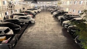 A long row of parked cars leading to a building with multiple windows. - Duangdeerojehouse (Chon Buri)