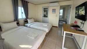 A hotel room with two beds, a TV, a desk, and a door leading to a bathroom. - Duangdeerojehouse (Chon Buri)