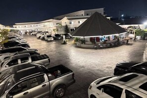 A parking lot with several cars and a building in the background. - Duangdeerojehouse (Chon Buri)