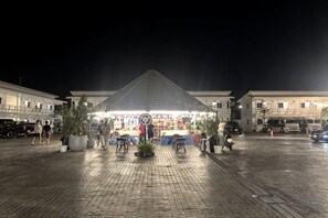 An outdoor market area with a central structure, potted plants, and a paved ground. - Duangdeerojehouse (Chon Buri)