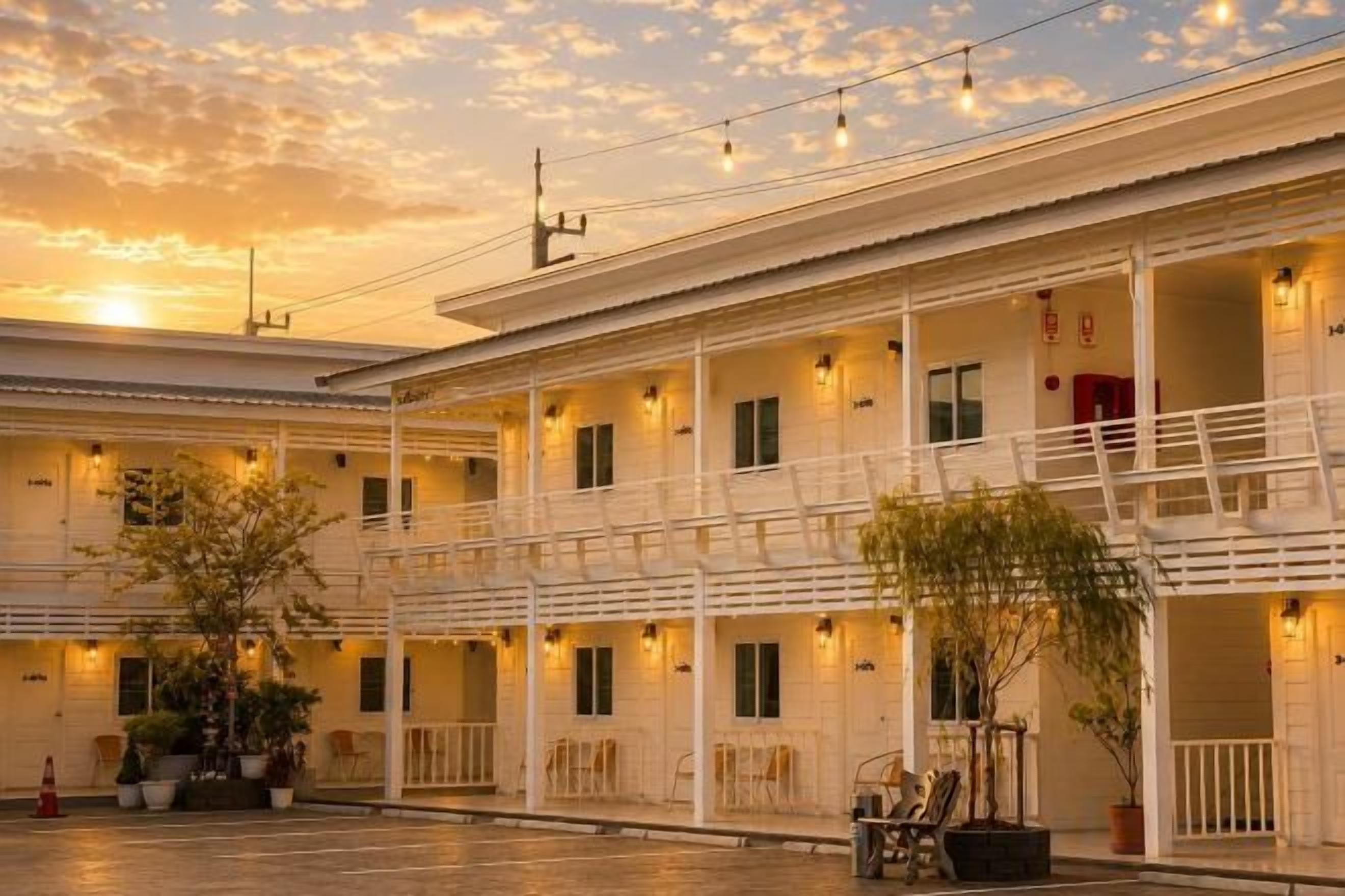 A hotel with multiple floors, balconies, and outdoor seating areas.