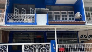 A two-story building with a blue facade, white window frames, and a balcony with a decorative metal railing. - Deng Ba Hostel Bangkok (Bangkok)