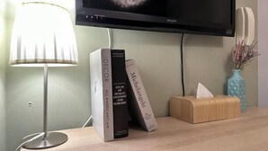 Un bureau avec une lampe, un écran affichant une image de galaxie, et des livres intitulés « Décoration » et « Michel-Ange ».