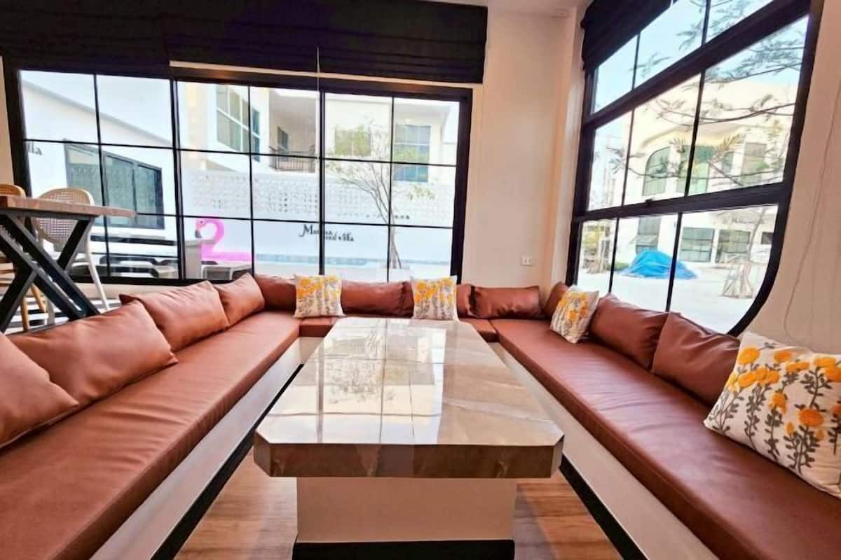 A modern living room with a large window, a sofa set, and a coffee table.