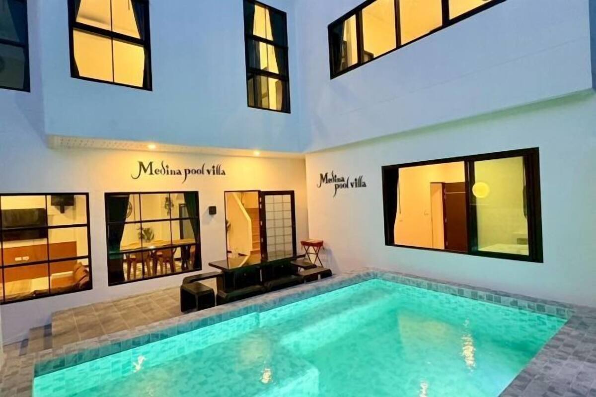 A swimming pool area with a sign reading "Medina pool villa".