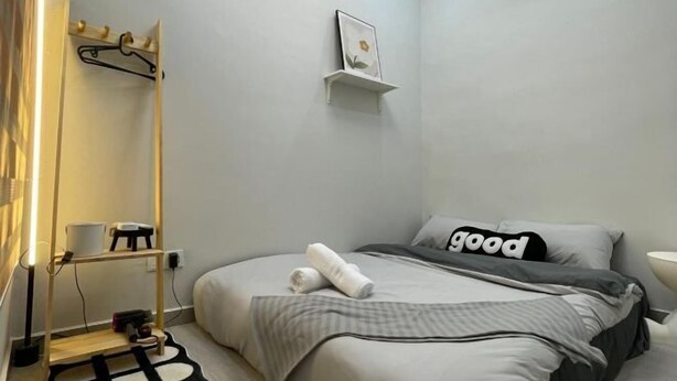 A neatly arranged bedroom with a bed, a bedside table, a hanging light, and a wall-mounted shelf.
