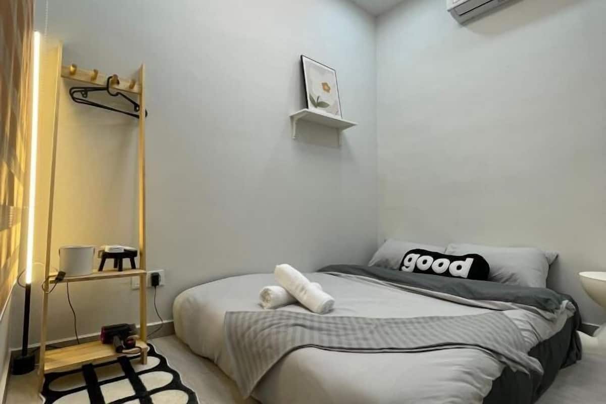 Une chambre à coucher bien rangée, avec un lit, une table de chevet, une lampe suspendue et une étagère fixée au mur.