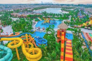 A water park with multiple slides and pools, surrounded by palm trees. - Emiii House - Homestay Near The Wave Park Vinhomes Ocean Park 2 (Nghia Tru)
