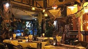 An indoor dining area with tables covered in yellow tablecloths, wooden chairs, and hanging light fixtures. - Emiii House - Homestay Near The Wave Park Vinhomes Ocean Park 2 (Nghia Tru)