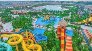 A water park with multiple slides and pools surrounded by palm trees. - Emiii House - Homestay Near The Wave Park Vinhomes Ocean Park 2 (Nghia Tru)