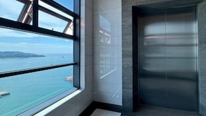 A modern elevator with a view of the sea through a large window. - Peaceful JQ homestay (Kota Kinabalu)