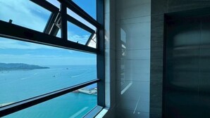 A modern interior with a large window offering a view of a coastal area. - Peaceful JQ homestay (Kota Kinabalu)