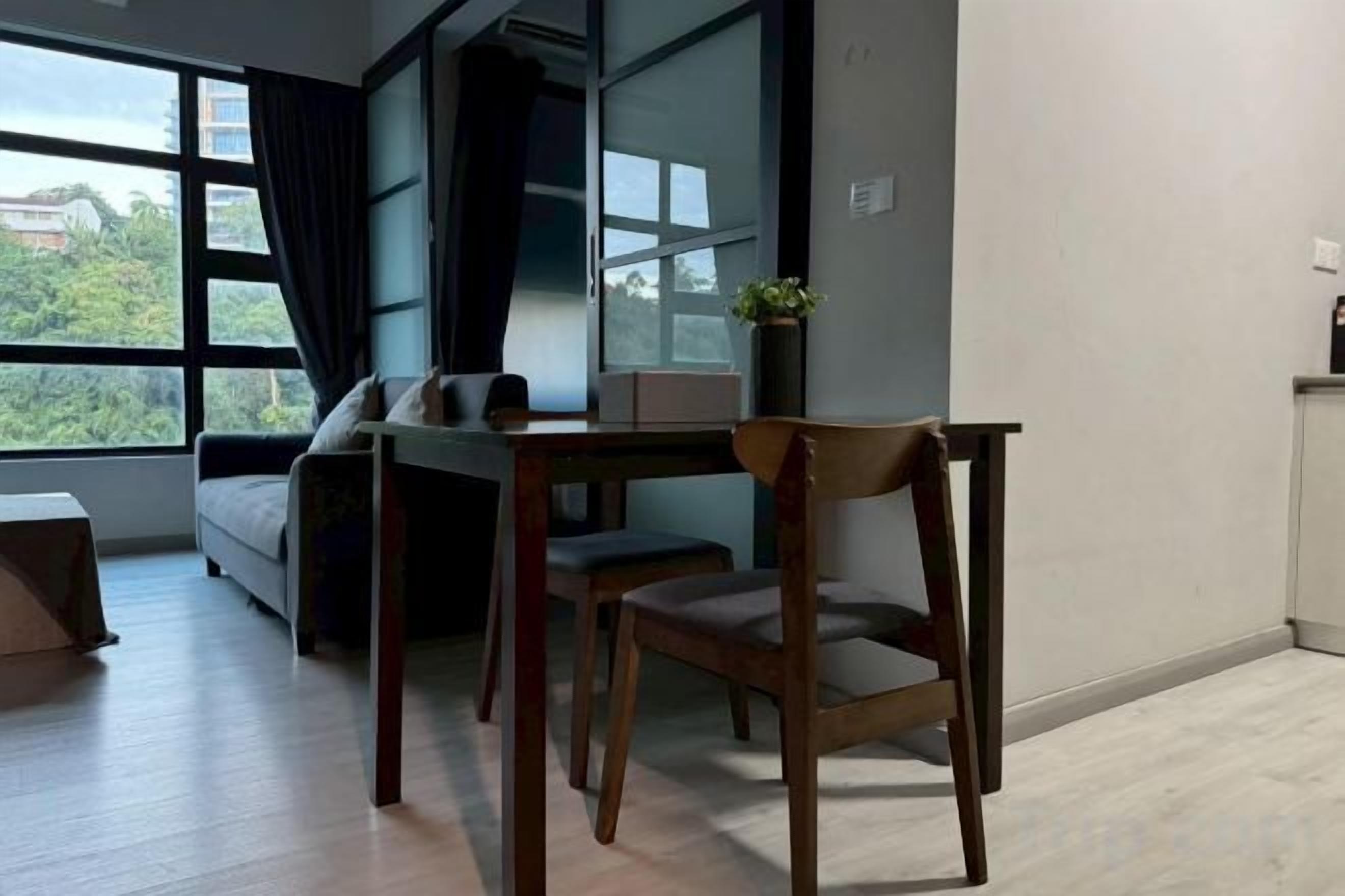 Un salon moderne comprenant un canapé, une table à manger avec des chaises et une grande fenêtre donnant sur un paysage verdoyant.