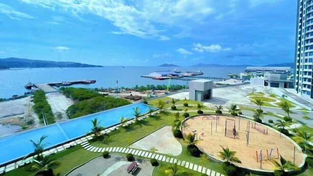 A resort with a swimming pool, a sandy area, and a view of the sea. - Peaceful JQ homestay (Kota Kinabalu)