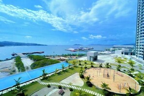 A resort with a pool, beach area, and views of the sea.