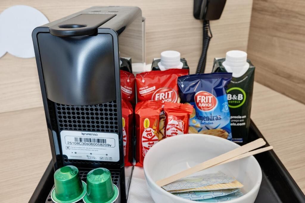 A coffee machine, snacks, a bowl with chopsticks, and a B&B juice carton.