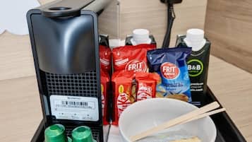 A coffee machine, snacks, a bowl with chopsticks, and a B&B juice carton.