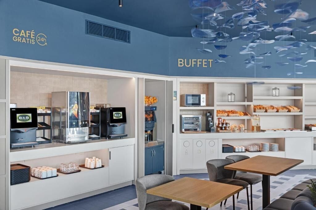 A buffet area with a coffee station, seating, and a wall with hanging fish decorations.