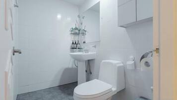 Un baño con inodoro, lavabo y espejo.