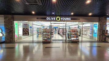 Una tienda llamada 'OLIVE YOUNG' con fachada de vidrio y suelo de baldosas.