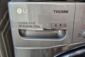 A metallic surface with the LG logo and the text 'TROMM DD Inverter 21kg'.