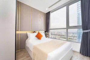 Una habitación de hotel moderna con un ventanal grande, una cama y vistas a la ciudad.