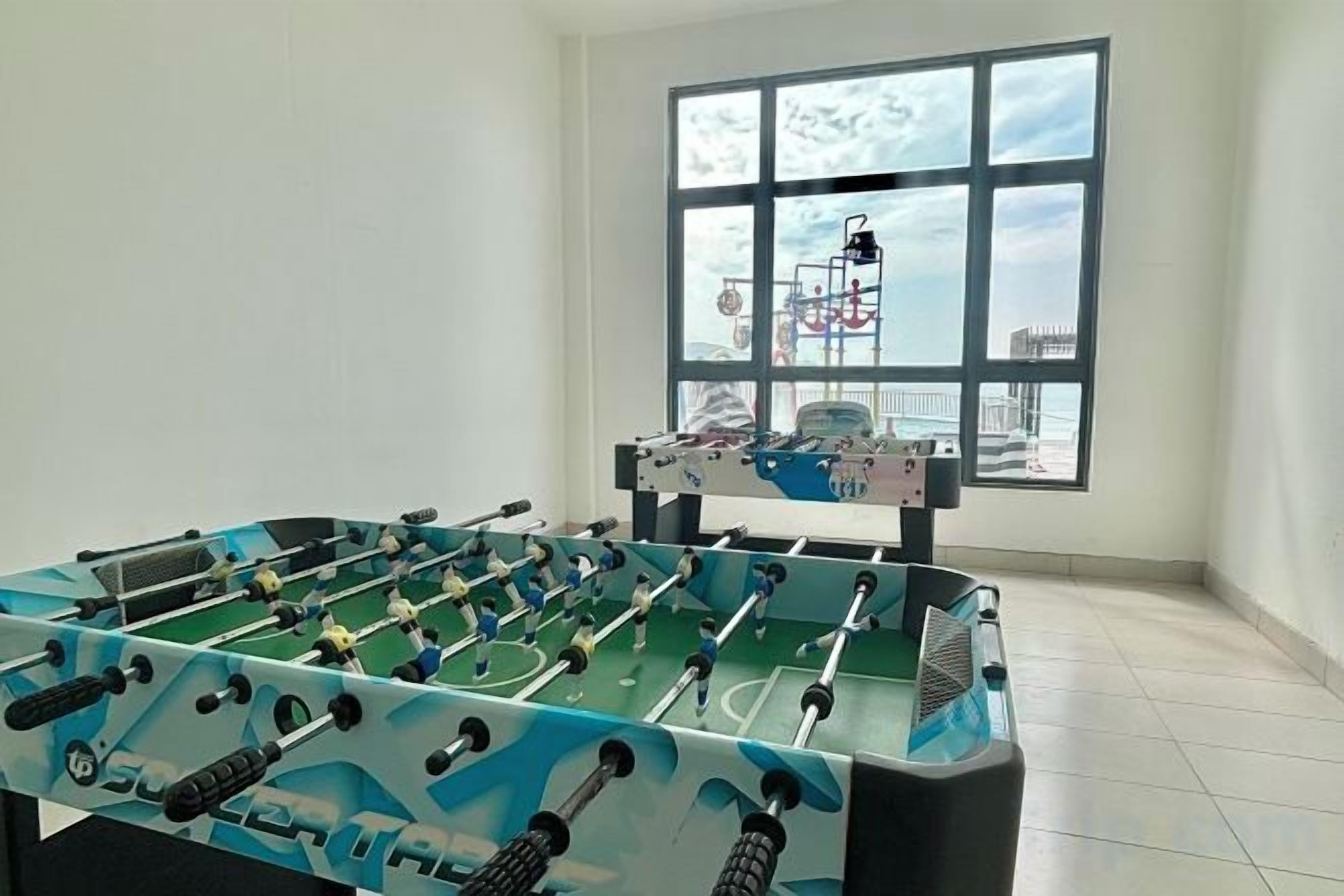 A foosball table in a room with a large window.