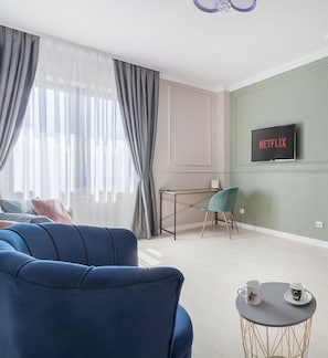 Departamento Deluxe, balcón, vista a la ciudad | Área de sala de estar | Smart TV de 108 cm con canales por cable
