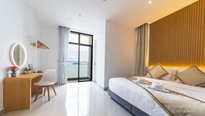 Une chambre d’hôtel moderne, dotée d’un grand lit, d’un bureau avec une chaise, d’un miroir et offrant une vue sur l’extérieur.