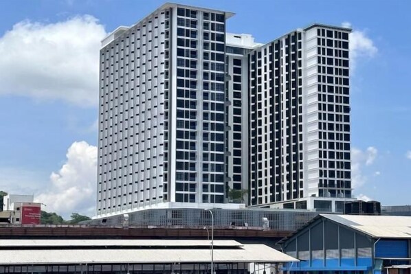 A high-rise building with a grid-like facade, multiple floors, and a flat roof.