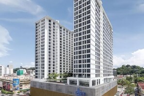 Ein Hochhaus mit modernem architektonischen Design, das eine rasterförmige Fassade und ein flaches Dach aufweist.