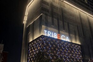 Un edifici amb el rètol 'TRIBECA' il·luminat de nit.