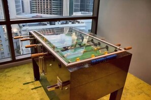 Une table de baby-foot dans une pièce avec une grande fenêtre.