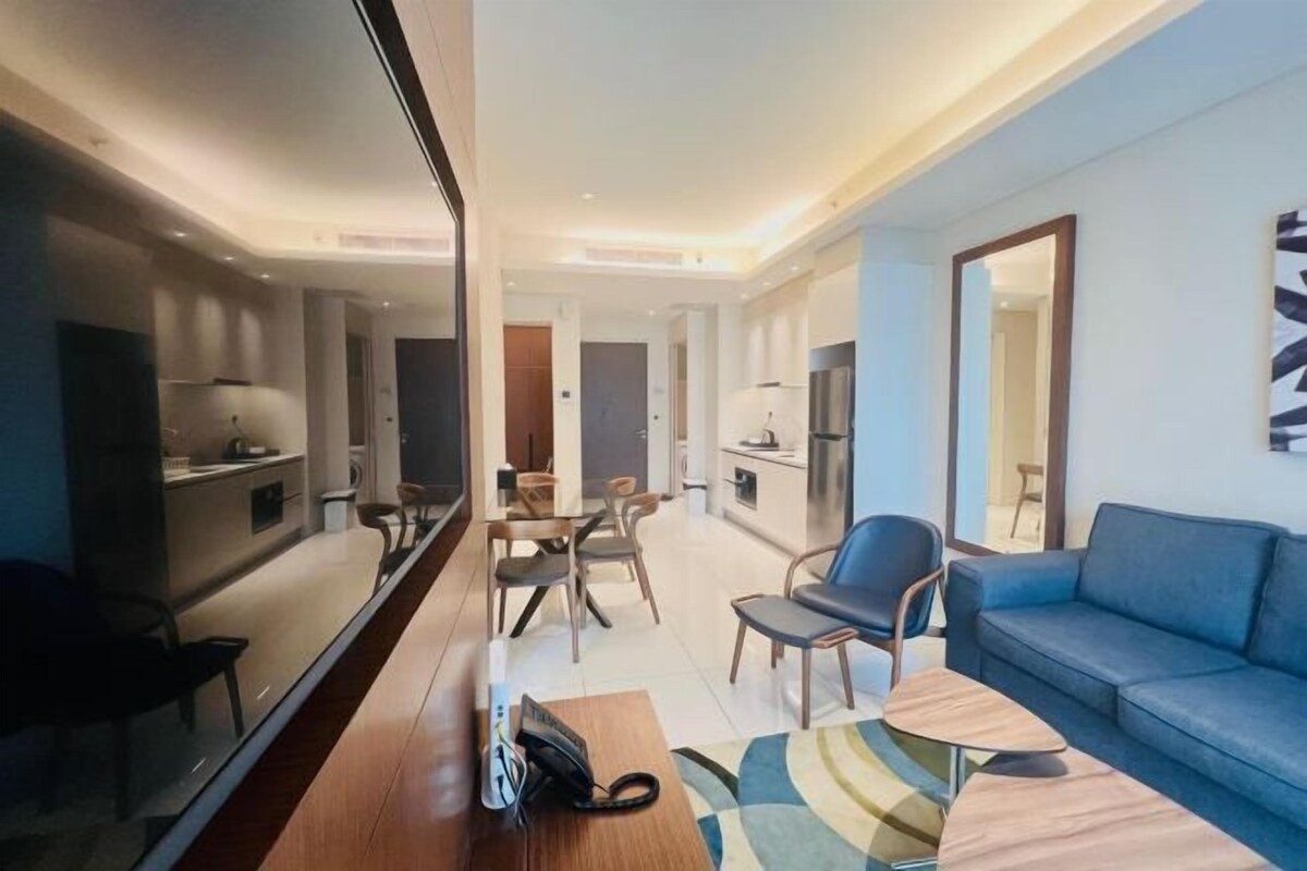 Une chambre d’hôtel moderne avec un coin repas, un canapé et un miroir.