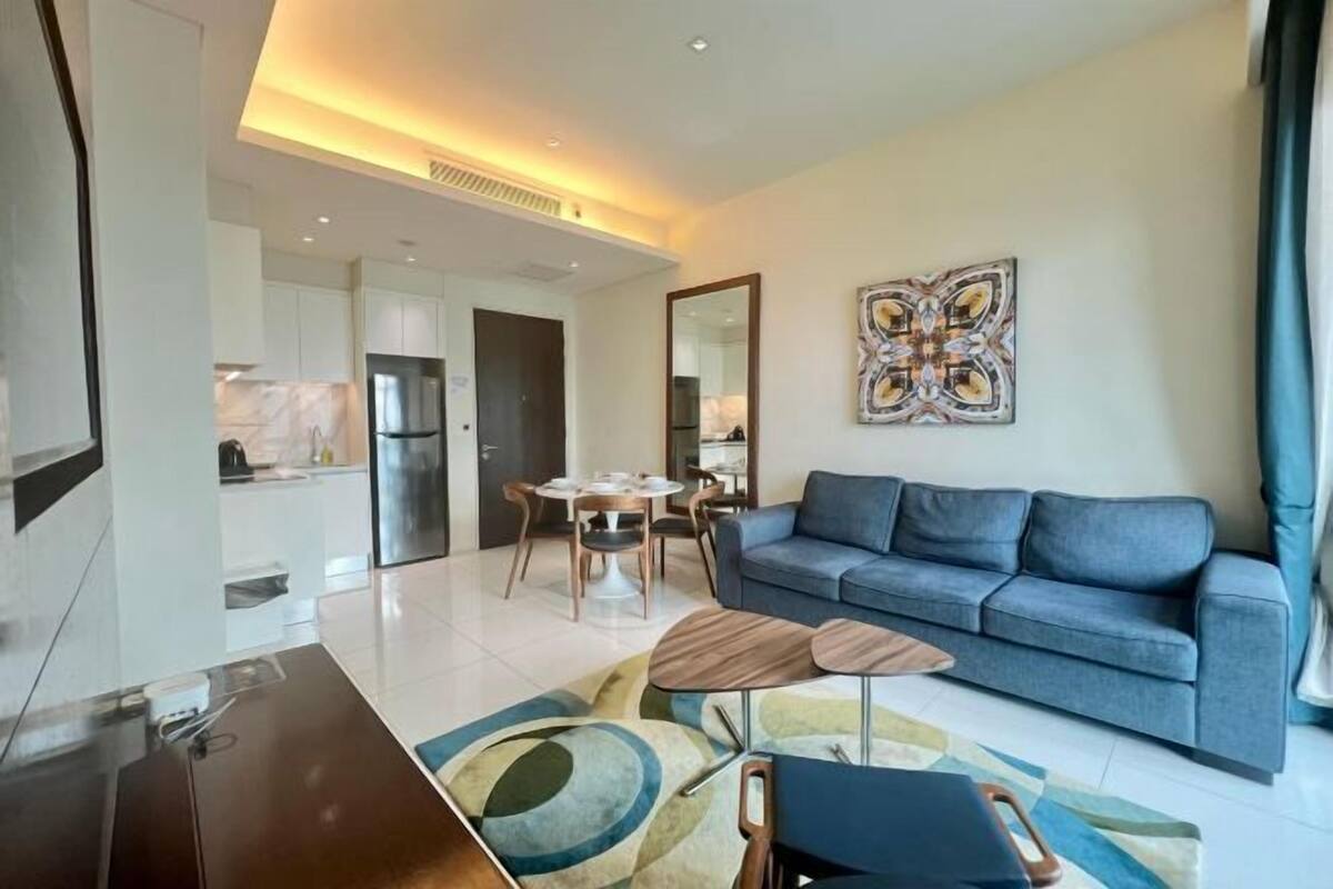 Een moderne woonkamer met een bank, een salontafel en een eethoek met stoelen.