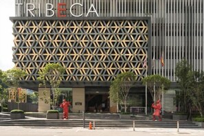 Un bâtiment moderne à la façade géométrique, sur lequel le nom « TRIBECA » est clairement affiché.