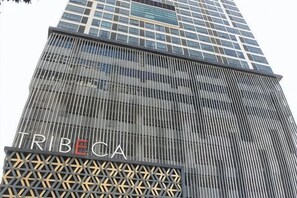 Un edificio alto con la palabra 'TRIBECA' visible en su fachada.
