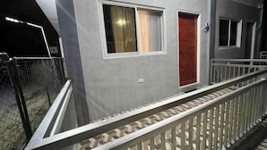 A building with a balcony, a door, and a window. - Cozy Studio Type unit w/ TV, Wifi, hotshower & ref (Cotabato)