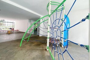 A playground with climbing structures and a blue slide. - Homestay near to PWTC @ BY AWESOMESTAY (Kuala Lumpur)
