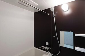A modern bathroom with a shower, a mirror, and a towel rack.