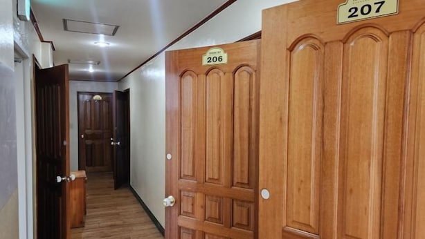 Un couloir avec des portes en bois, chacune portant un numéro.