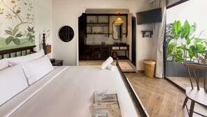 A hotel room with a large bed, a view of the kitchen, and a dining area with a table and chairs. - Tropical Dorm Hostel Da Nang by Haviland (Da Nang)