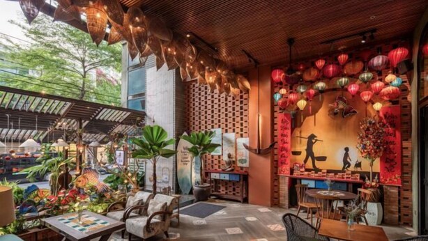 A restaurant with wooden ceiling, hanging lanterns, and a variety of plants. - Tropical Dorm Hostel Da Nang by Haviland (Da Nang)