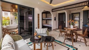 A modern living room with a sofa, a dining table with chairs, a ceiling fan, and a view of the outside. - Tropical Dorm Hostel Da Nang by Haviland (Da Nang)
